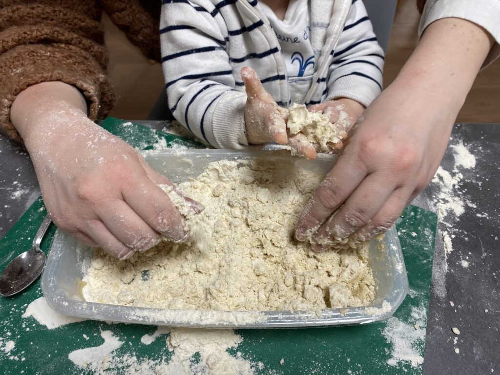 enfant qui mélange de la farine et de l'huile