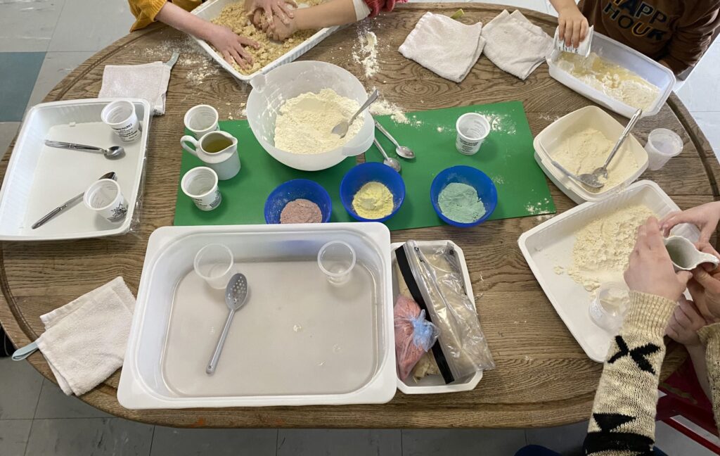 enfant qui mélange de la farine et de l'huile sable magique